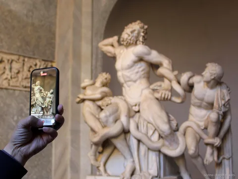 Hôte aidant des visiteurs à l'enregistrement du billet d'entrée des Musées du Vatican